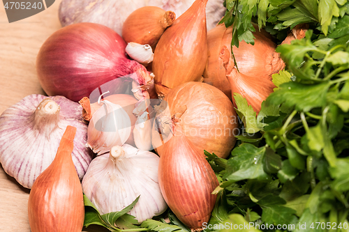 Image of garlic onion shallot parsley on a wooden board