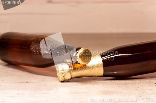 Image of a bottle of blonde beer and a bottle of amber beer lying down