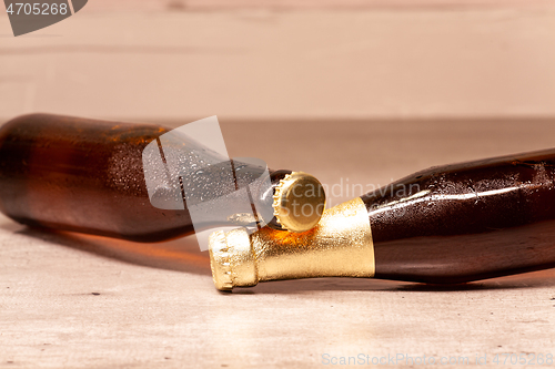 Image of a bottle of blonde beer and a bottle of amber beer lying down
