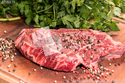 Image of steak of beef on a wooden board with spices and parsley