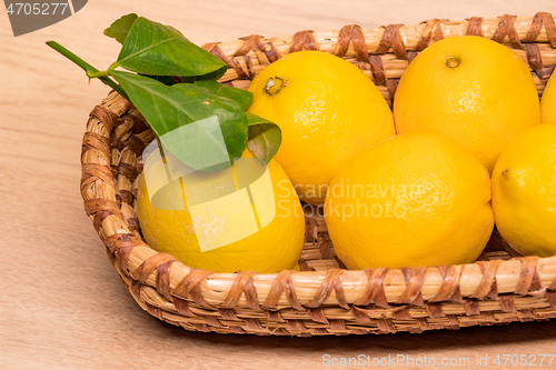 Image of yellow lemons in a small wooden basket