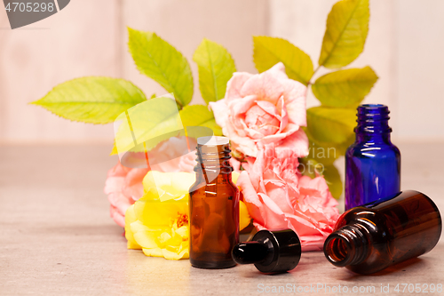 Image of rose flowers and bottles of essential oils for aromatherapy