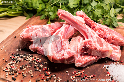 Image of raw lamb chops on a wooden board for barbecue