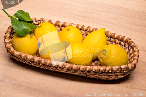 Image of yellow lemons in a small wooden basket