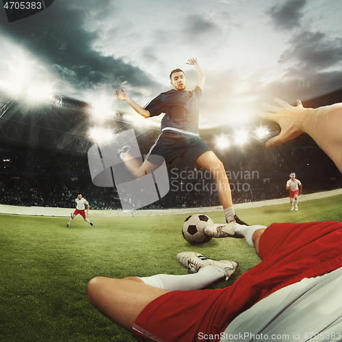 Image of Two men are playing soccer and they compete with each other