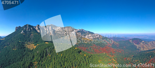 Image of Aerial view of rocky mountain and colored forest