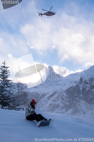 Image of rescue team with a red helicopter rescuing a hurt skier