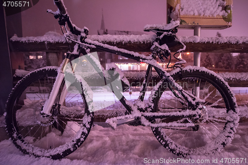 Image of parked bicycle covered by snow