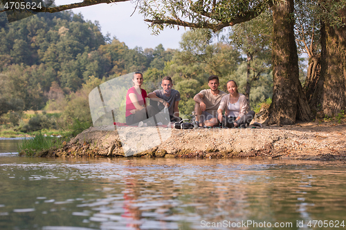 Image of friends smoking hookah on the river bank