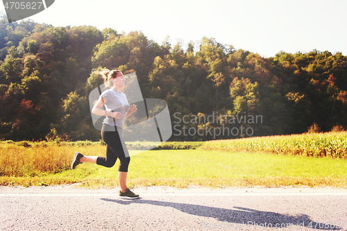 Image of woman jogging along a country road