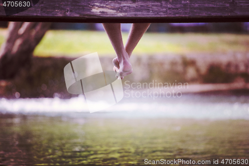 Image of people sitting at wooden bridge