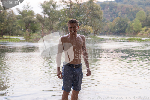 Image of man with a bare torso splashing water