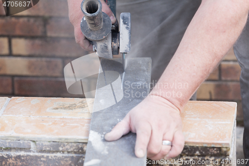 Image of tiler cutting a tile with a grinder