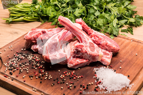 Image of raw lamb chops on a wooden board for barbecue