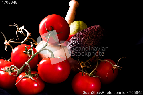 Image of large red and ripe tomatoes with a mortar and pestle in olive wo