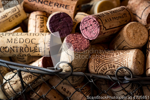 Image of old cork stoppers of French wines in a wire basket