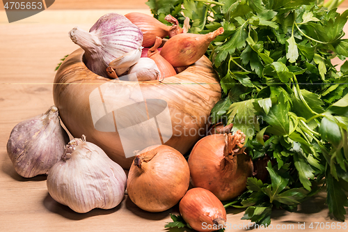 Image of garlic onion shallot parsley with pestle and olive wood mortar