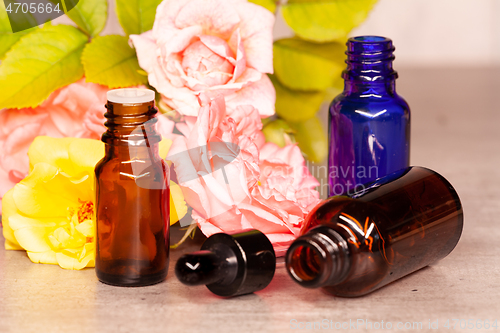 Image of rose flowers and bottles of essential oils for aromatherapy