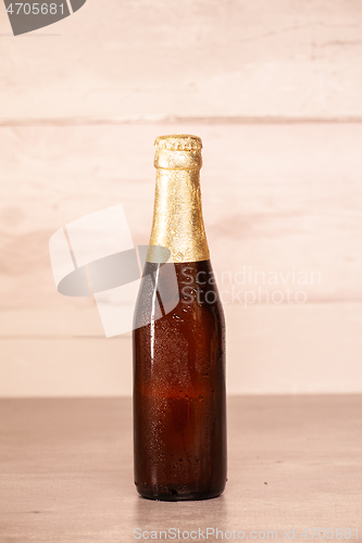 Image of a bottle of blonde beer with golden paper