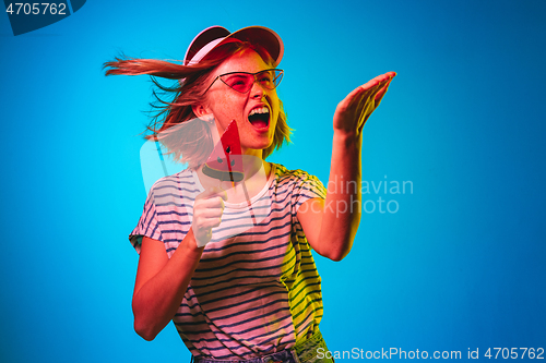 Image of Beautiful woman in neon light isolated on blue studio background