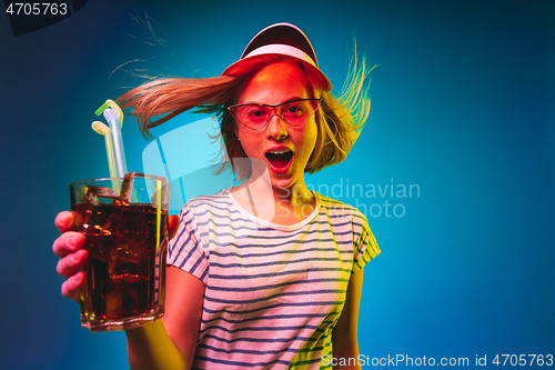 Image of Beautiful woman in neon light isolated on blue studio background