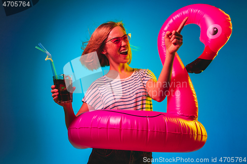 Image of Beautiful woman in neon light isolated on blue studio background