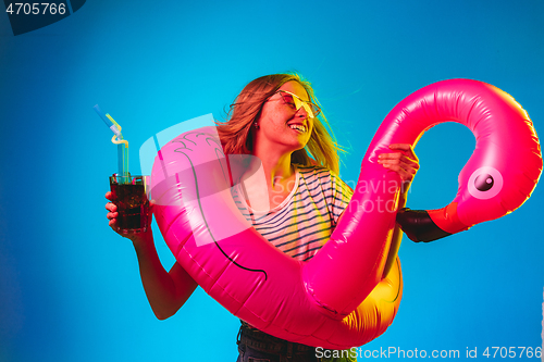 Image of Beautiful woman in neon light isolated on blue studio background