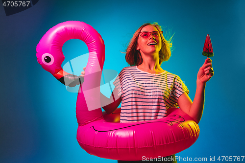 Image of Beautiful woman in neon light isolated on blue studio background