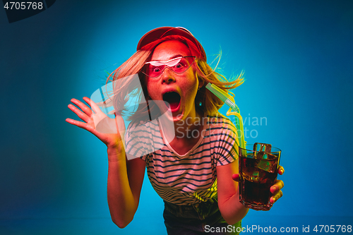 Image of Beautiful woman in neon light isolated on blue studio background