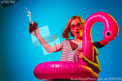 Image of Beautiful woman in neon light isolated on blue studio background