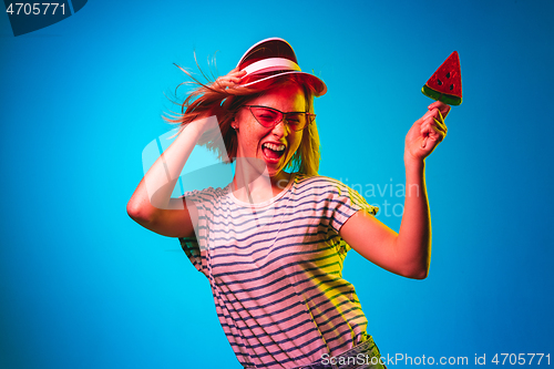 Image of Beautiful woman in neon light isolated on blue studio background