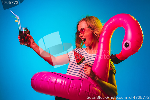 Image of Beautiful woman in neon light isolated on blue studio background