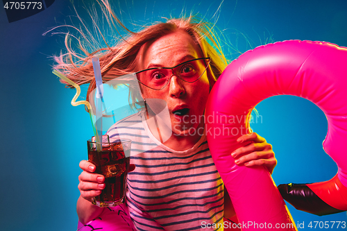 Image of Beautiful woman in neon light isolated on blue studio background