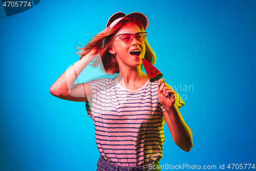 Image of Beautiful woman in neon light isolated on blue studio background