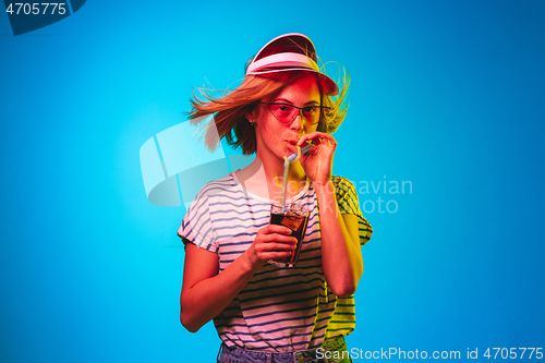 Image of Beautiful woman in neon light isolated on blue studio background