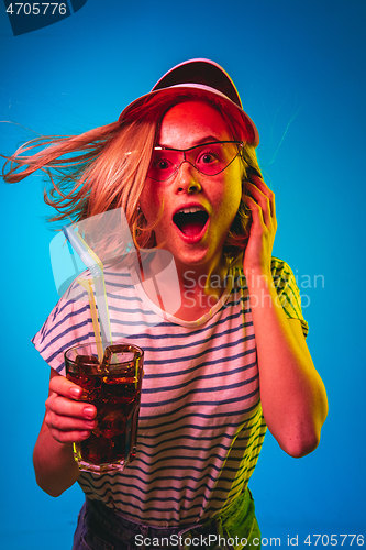 Image of Beautiful woman in neon light isolated on blue studio background