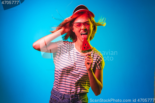 Image of Beautiful woman in neon light isolated on blue studio background