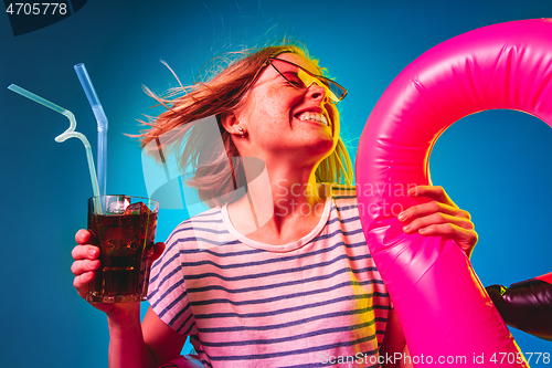 Image of Beautiful woman in neon light isolated on blue studio background