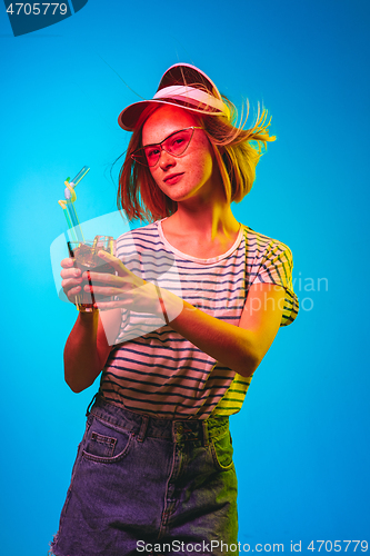 Image of Beautiful woman in neon light isolated on blue studio background