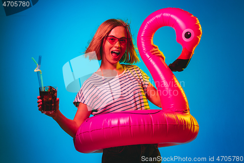 Image of Beautiful woman in neon light isolated on blue studio background