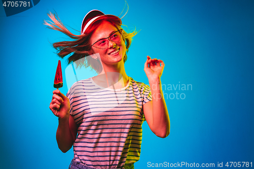 Image of Beautiful woman in neon light isolated on blue studio background