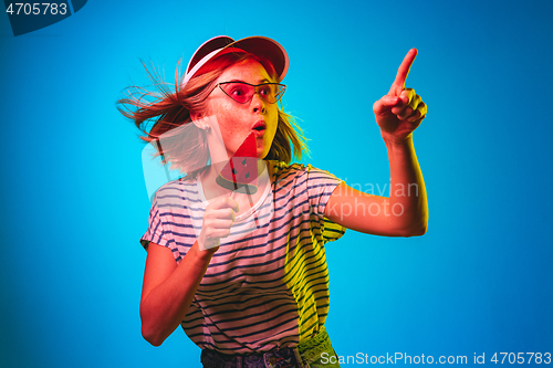 Image of Beautiful woman in neon light isolated on blue studio background