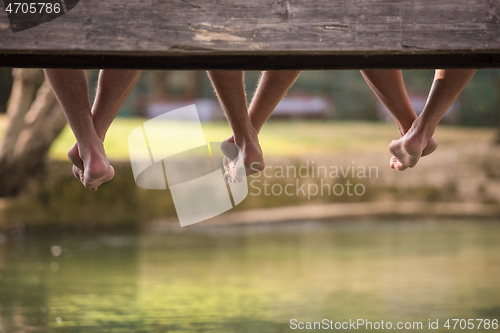 Image of people sitting at wooden bridge