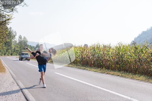 Image of happy couple jogging along a country road