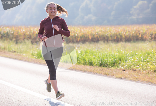 Image of woman jogging along a country road