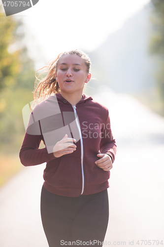 Image of woman jogging along a country road