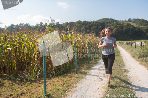 Image of woman jogging along a country road