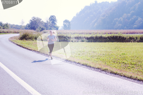 Image of woman jogging along a country road