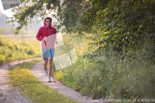 Image of man jogging along a country road