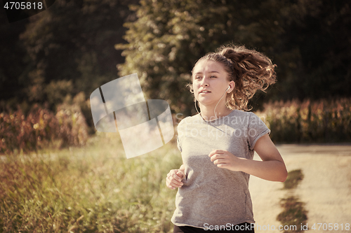 Image of woman jogging along a country road